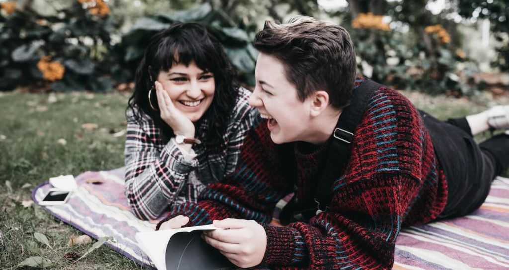 couple on picnic blanket sharing a laugh