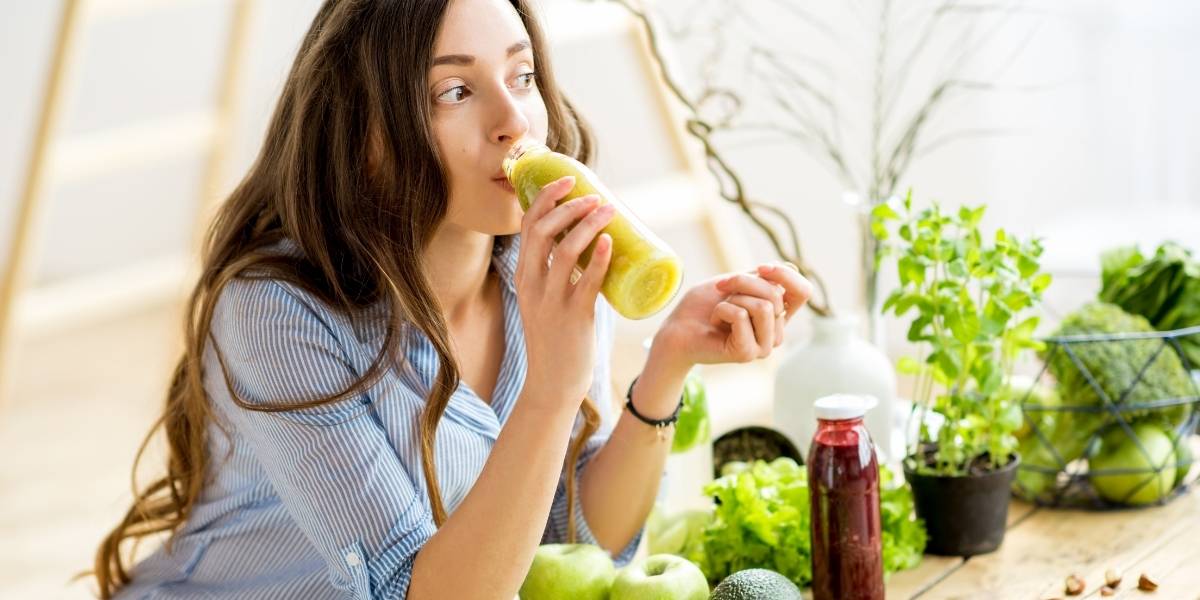 woman drinking green smoothie